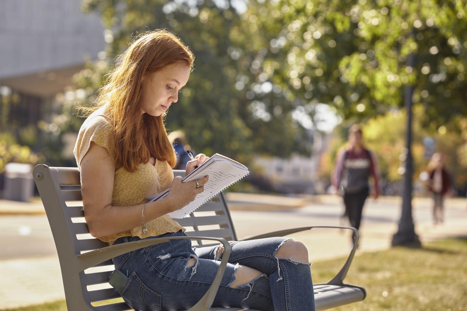 一位<a href='http://jolp.ngskmc-eis.net'>全球十大赌钱排行app</a>学院的学生在校园里的长椅上读书.